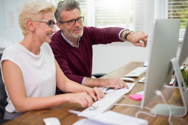 a man and woman looking at a computer screen