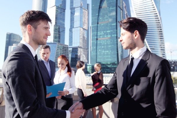 a man shaking hands with other people in the background